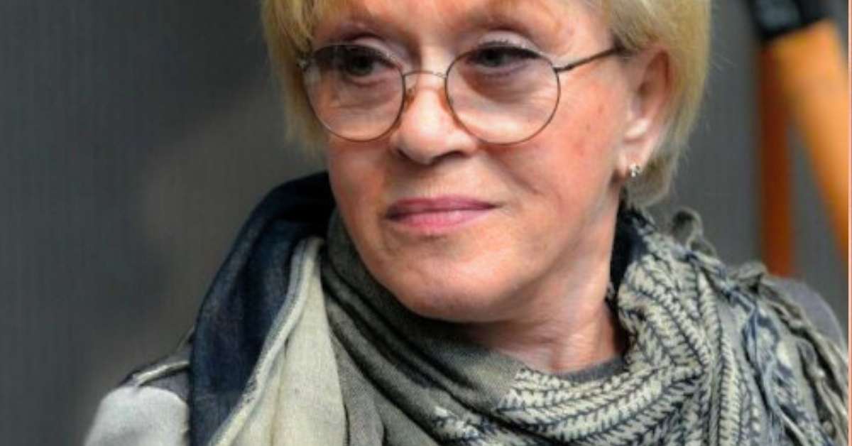 Пожилая женщина у окна с мягким светом на лице, спокойствие, размышление и ощущение внутреннего мира