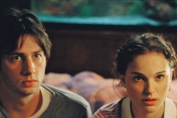 Женщина с чашкой кофе у окна, смотрит фильмы для вдохновения и уюта осенью