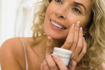 Женщина 40+ наносит сыворотку для лица с ретинолом, витамином C и пептидами — антивозрастной уход за кожей